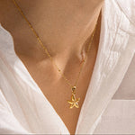 Load image into Gallery viewer, Gold starfish necklace worn by a person in a white shirt