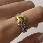 Load image into Gallery viewer, Gold heart-shaped ring on a finger against a neutral background