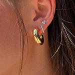Load image into Gallery viewer, Close-up of an ear wearing gold hoop earrings with a heart-shaped stud.