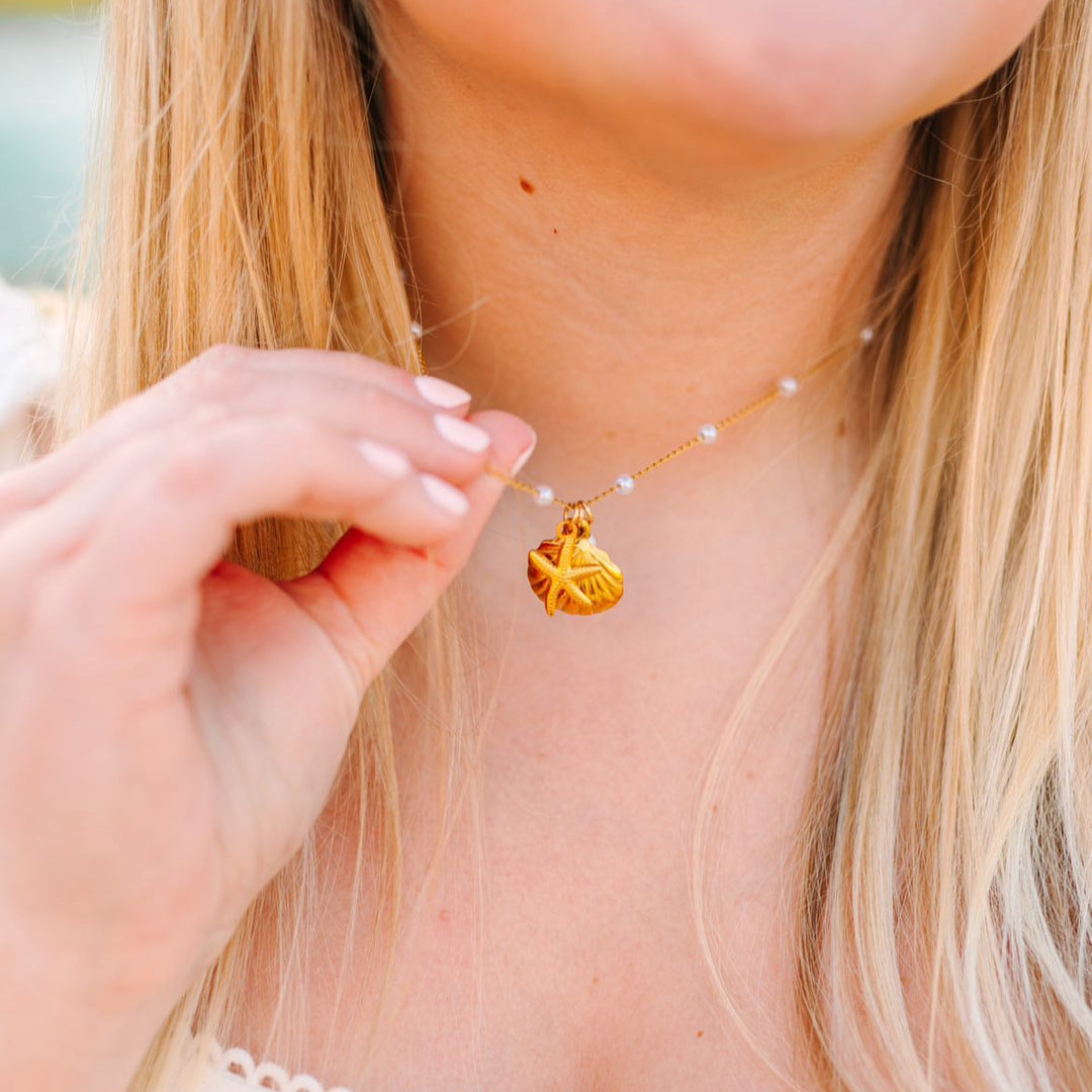 Close-up of a person wearing a delicate necklace with a small pendant.