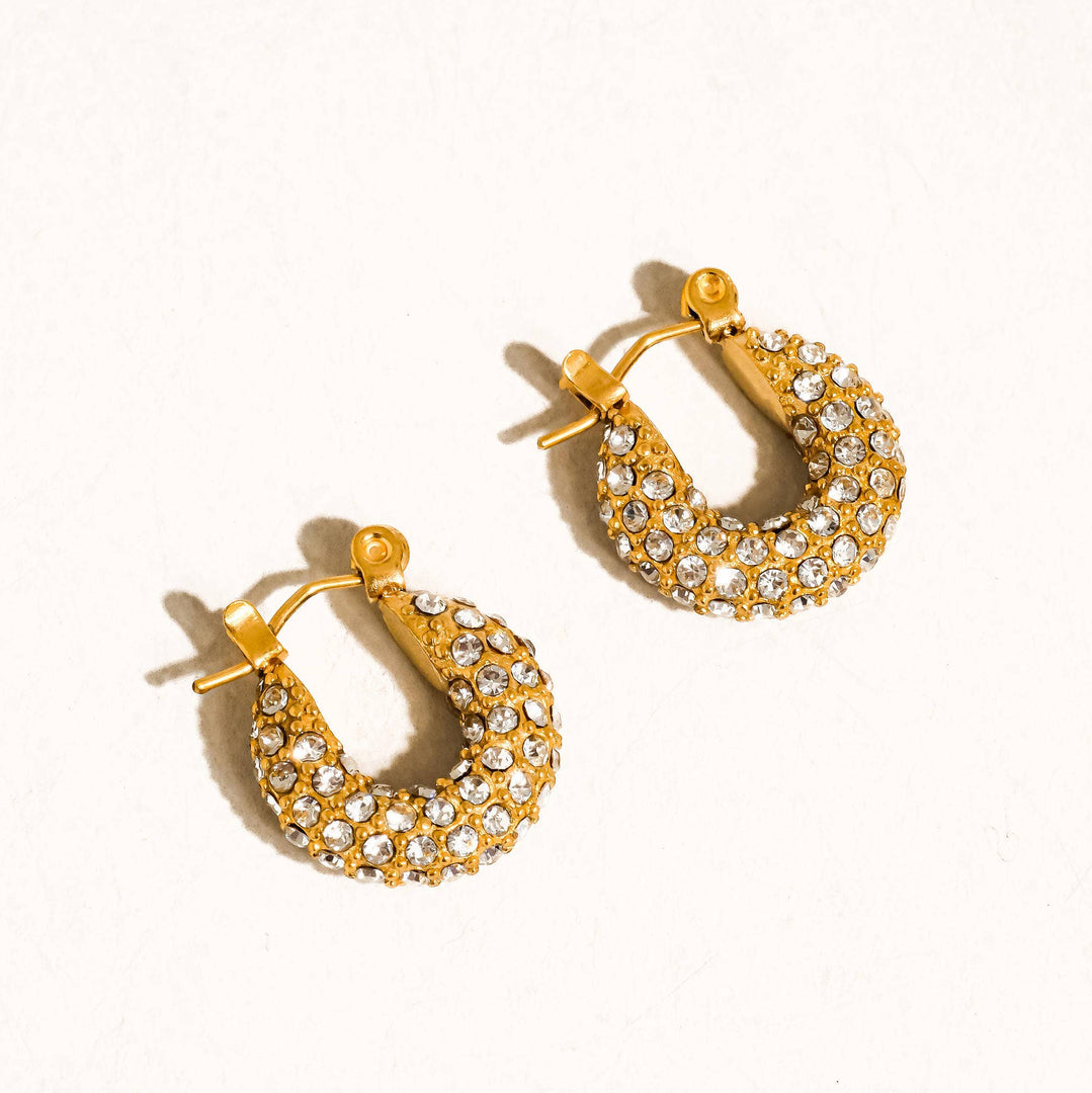 Gold hoop earrings with embedded stones on a white background