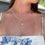 Load image into Gallery viewer, Woman wearing a pearl necklace with a sun pendant outdoors
