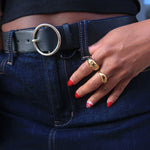 Load image into Gallery viewer, Person wearing a black belt with a gold buckle, holding a blue bag.
