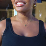 Load image into Gallery viewer, Woman wearing a black crop top and brown jacket indoors
