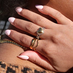 Load image into Gallery viewer, Close-up of a person wearing gold earrings and rings with a leopard print pattern in the background.