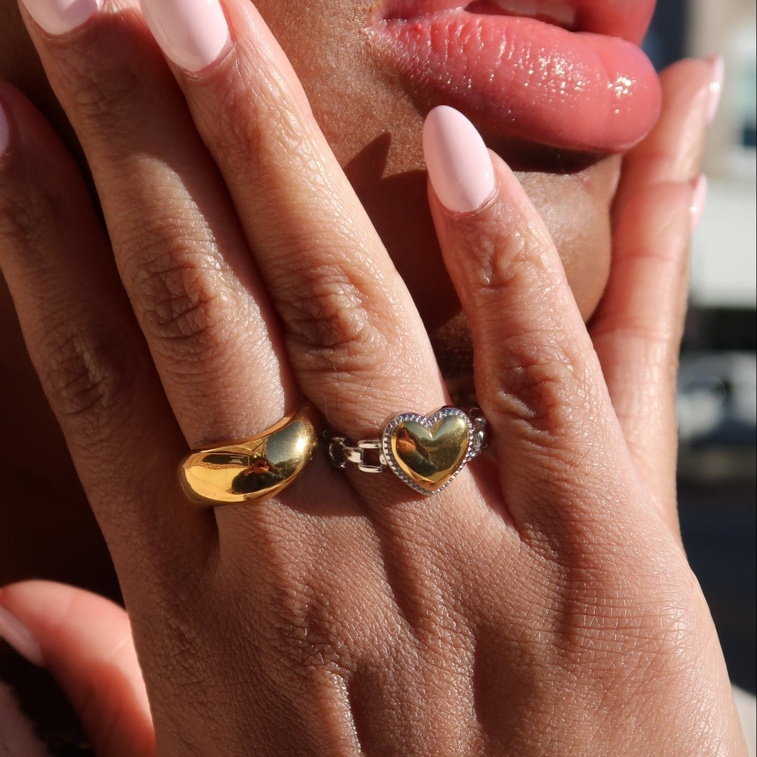 Close-up of a hand with gold rings on a blurred background