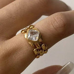 Load image into Gallery viewer, Gold ring with a large diamond on a person's finger against a neutral background