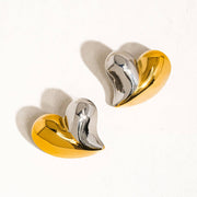 Pair of gold and silver heart-shaped earrings on a white background